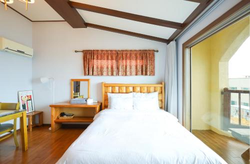 a bedroom with a large bed and a window at New Coastal Scenery in Jeju