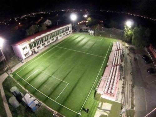 a tennis court is lit up at night at FRIENDS RESIDENCE Apartments in Timişoara