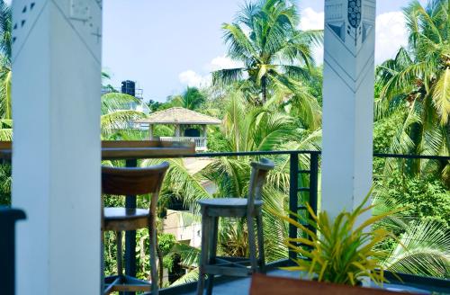 a view from the balcony of a resort with palm trees at Habibi Hostel & Restaurant in Unawatuna