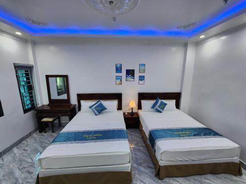two beds in a room with blue lights at View Point - Anh Quan in Cat Ba