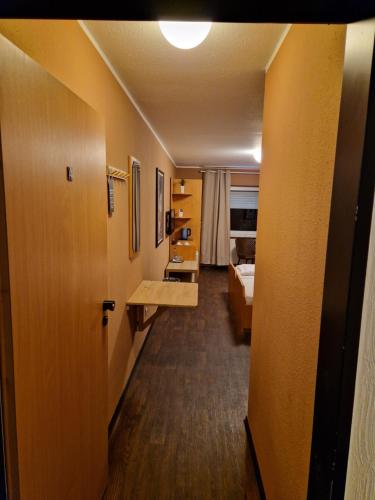 a hallway leading to a room with a bed and a room with a hallway at Hotel Restaurant Oliva in Nordwalde