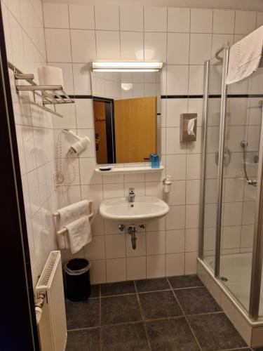 a bathroom with a sink and a shower at Hotel Restaurant Oliva in Nordwalde