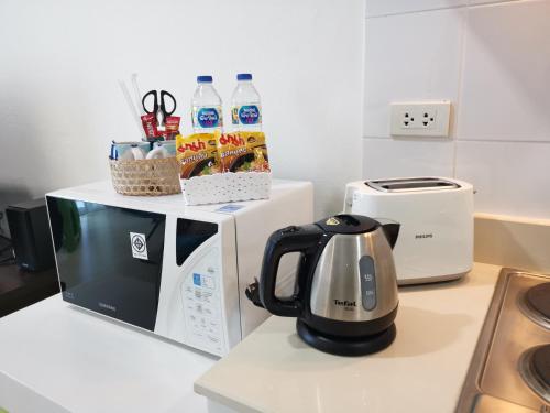 a tea kettle sitting on top of a microwave at The Beach Bangsaen Condo Sea View Room 327-62 Top Floor-Free Netflix in Ban Bang Saen (1)