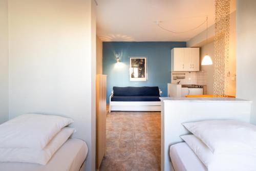 a living room with a couch and a kitchen at Pelagos Paradise Seafront Studio by Booking Kottas in Kalamitsi