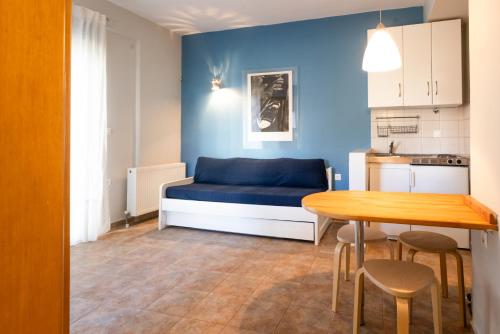 a room with a bed and a table and a kitchen at Pelagos Paradise Seafront Studio by Booking Kottas in Kalamitsi