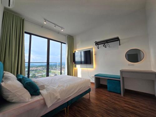 a bedroom with a bed and a desk and a television at K Avenue Kota Kinabalu by Merveille - Sabah in Donggongon