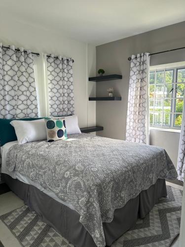 a bedroom with a large bed and a window at Villa Nola in Port-of-Spain