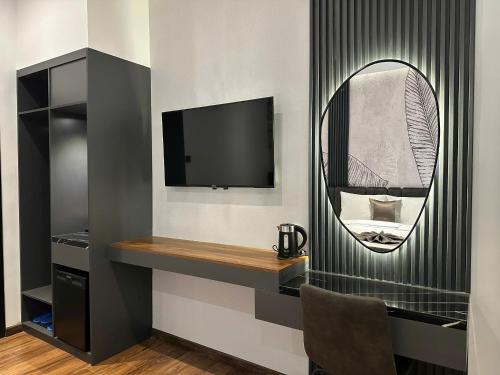 a room with a tv and a mirror at LION 11 Can Tho Hotel in Can Tho