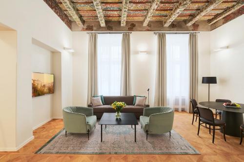 a living room with a couch and chairs and a table at Hotel CUBE Prague in Prague