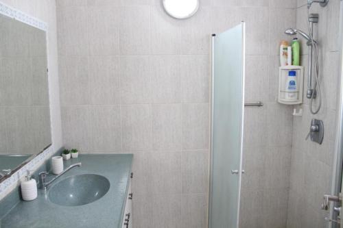 a bathroom with a sink and a shower at ספרינג in Qiryat Shemona