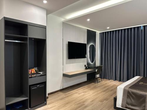 a bedroom with a bed and a desk with a television at LION 11 Can Tho Hotel in Can Tho