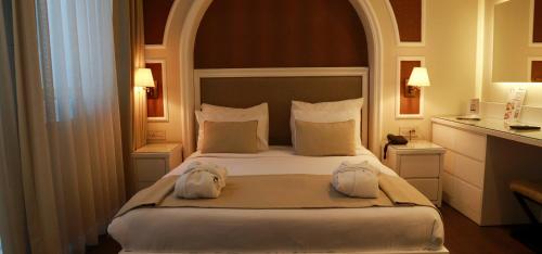 a bedroom with a large bed with two towels on it at DBD Hotel Bayraklı in Bayrakli