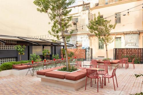 un patio con tavoli, sedie e alberi di Okupa ad Atene