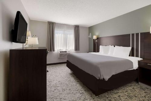 a hotel room with a bed and a flat screen tv at Quality Inn Hall of Fame in Canton