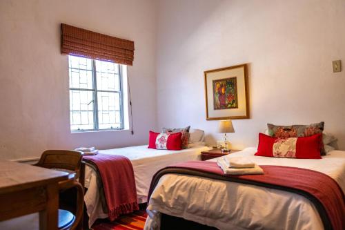 a room with two beds and a table and a window at HH 820 Accomodation in Groutfontein