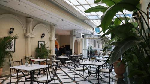 a dining room with tables and chairs and plants at DBD Hotel Bayraklı in Bayrakli