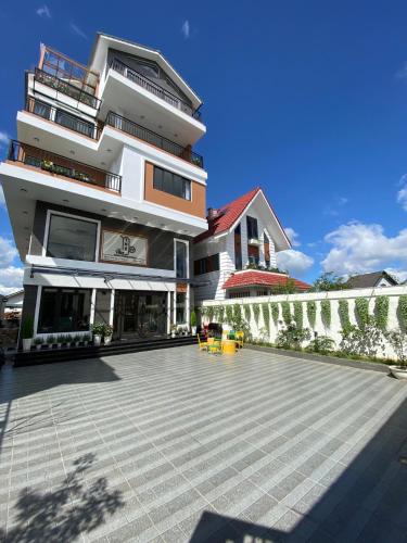 a large building with a patio in front of it at Thé Villa in Da Lat
