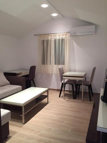 a living room with two tables and a couch at Apartments TMV Dragovic in Sveti Stefan