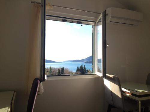a room with a window with a view of the water at Apartments TMV Dragovic in Sveti Stefan