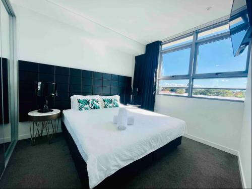 a bedroom with a large white bed and a window at Chatswood Exeutive Suites - 3beds2baths with Parking in Sydney