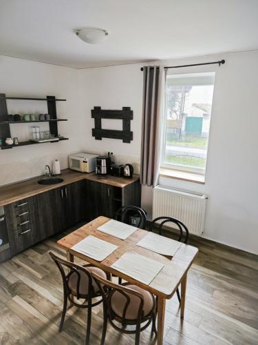 a kitchen with a table and chairs in a room at Corner Apartman in Sárvár