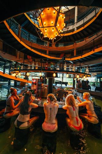 a group of people sitting in the water at a bar at Hivetel in Chalong 