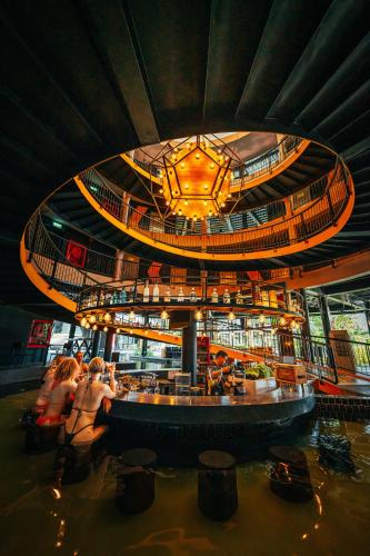 a building with a bar with people in the water at Hivetel in Chalong 
