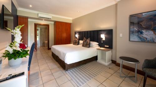 a hotel room with a bed and a living room at ANEW Resort Hunters Rest Rustenburg in Rustenburg