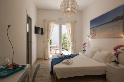 a bedroom with a bed and a table and a window at Coru e Mari in Pula