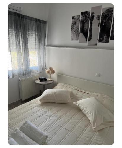 a bedroom with a large white bed with a window at Vila Veta in Galatas