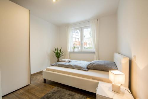 a bedroom with a bed and a window and a mirror at Möblierte Penthaus Wohnung in Baden-Baden
