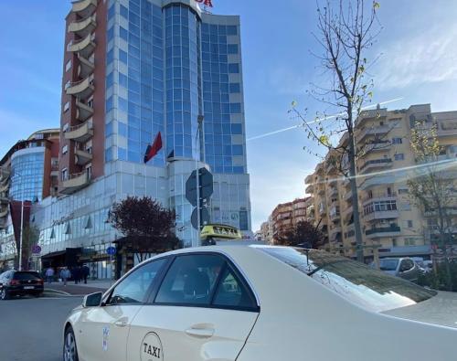 a white car parked in front of a building at Studioo Apartment in Tirana