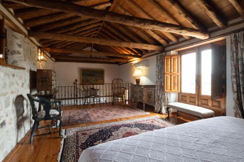a bedroom with a bed in a room with wooden ceilings at Cigarral del Carmen in Toledo