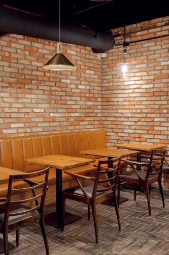 a row of wooden tables and chairs against a brick wall at Handpicked Hotel & Collections in Seoul