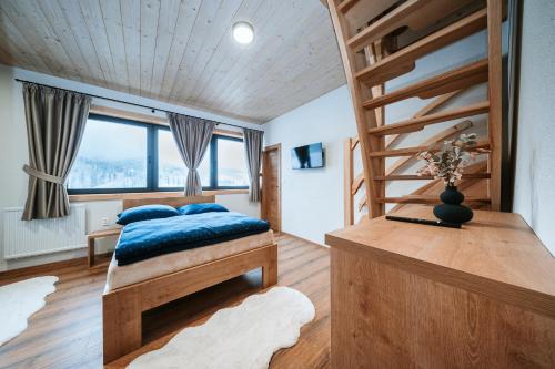 a bedroom with a bed with blue pillows at Chata Azarka in Beňuš