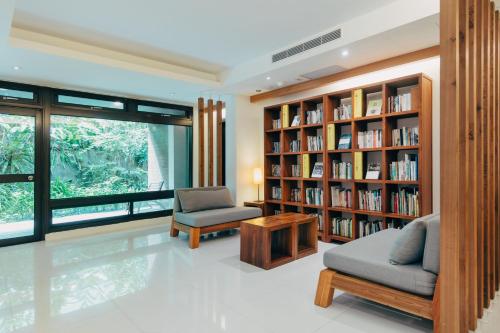 a library with two chairs and bookshelves at Adagio JinGuaShi in Jiufen