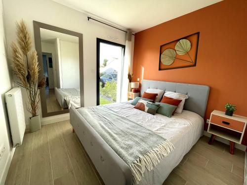 une chambre avec un grand lit avec un mur orange dans l'établissement Villa La Détente, à La Tranche-sur-Mer