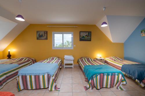a room with three beds and a window at Villa - Piscine chauffée, jacuzzi in Plouharnel