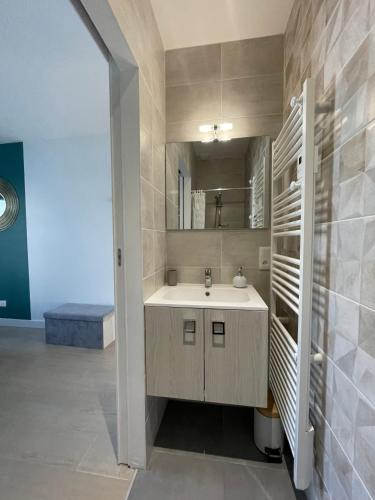 une salle de bain avec un lavabo et un miroir dans l'établissement Villa La Détente, à La Tranche-sur-Mer