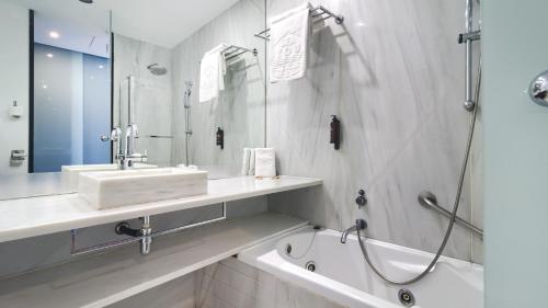 a bathroom with a sink and a bath tub at Sea You Hotel Port Valencia in Valencia