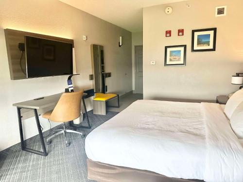 a hotel room with a bed and a desk and a tv at Comfort Inn & Suites Cartersville - Emerson Lake Point in Cartersville