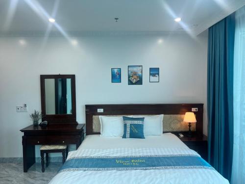 a bedroom with a bed and a desk and a mirror at View Point - Anh Quan in Cat Ba