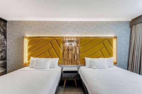 two beds sitting next to each other in a room at The Wander Hotel in Gatlinburg