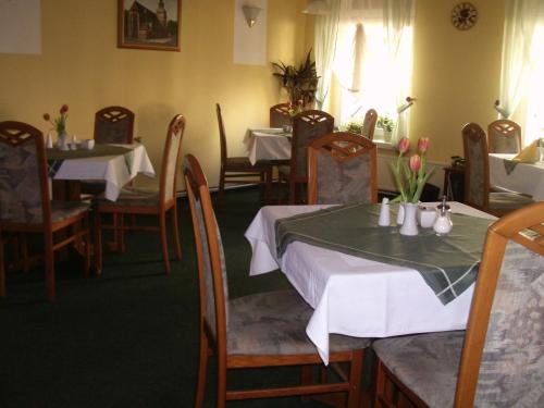 a restaurant with tables and chairs with flowers on them at Hotel-Restaurant Marcus in Malchin
