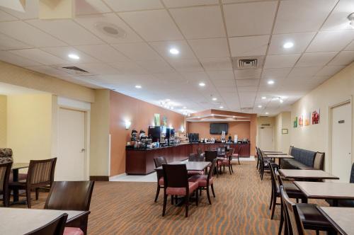 a dining room with tables and chairs and a bar at Quality Inn in Baltimore