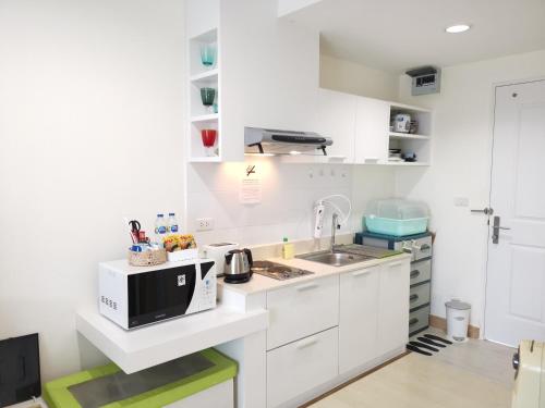 a white kitchen with a sink and a microwave at The Beach Bangsaen Condo Sea View Room 327-62 Top Floor-Free Netflix in Ban Bang Saen (1)