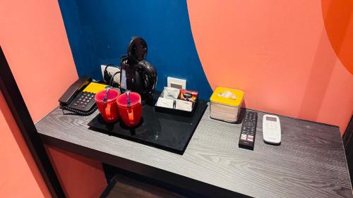 a table with red cups and a phone on it at Yellow Bee Resort Cililitan in Jakarta