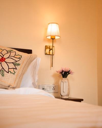 a hotel room with a bed with a vase of flowers at Banana Hostel Pushkar in Pushkar