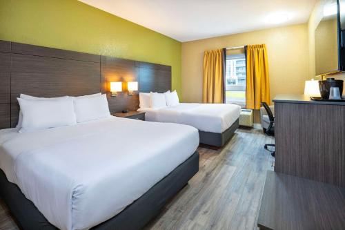 a hotel room with two beds and a television at Quality Inn & Suites in Grimsby