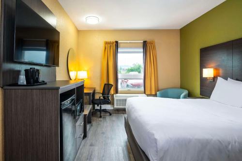 a hotel room with a bed and a window at Quality Inn & Suites in Grimsby